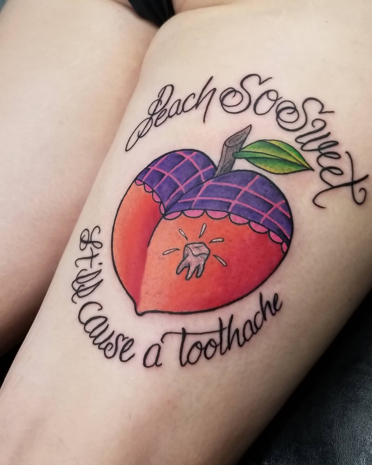 Tattoo of a peach with a tooth inside, text reads, "Peach so sweet, it'll cause a toothache"